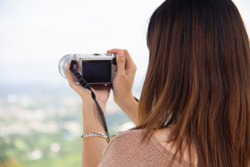 female  holding a professional camera. Female photographer with a professional camera.