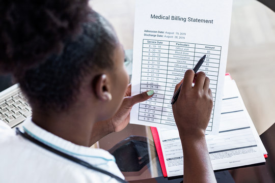 Healthcare costs and fees concept.Hand of smart doctor calculating medical costs in modern hospital. Doctor completing a Medical Claim Form by Stethoscope