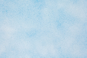 Winter background. Top view of snow texture on the blue background. Copy space.