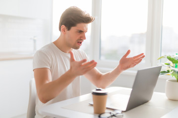 Entrepreneur angry and furious man with a laptop at home