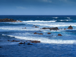 Atlantic waves and volcanic rocks on the shore at Puerto de la Cruz, Tenerife, Canary islands, Spain