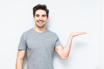 Young man showing something with his hand isolated on white background