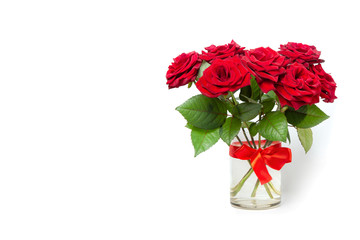 Bouquet of red roses in a glass vase on a white isolated background. Greeting card. Copy space.