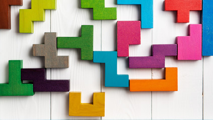 Top view on colorful wooden blocks folding on white wooden background