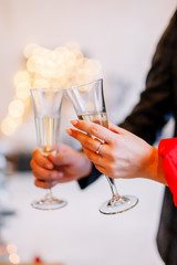 New Year 2020. New Year mood. Table with a gold tablecloth, decorated with candles and tableware for celebration. Festive still life by candlelight.A man pours champagne into a glass. Close-up.