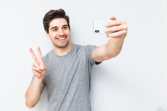 Happy young man taking a selfie photo isolated on white background