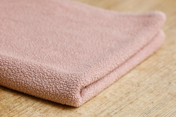 Fototapeta na wymiar Big soft pink folded towel on table