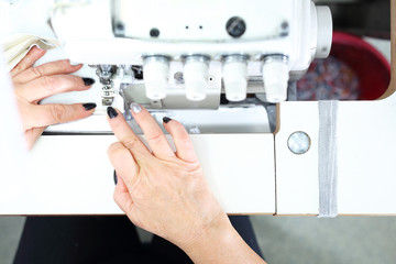 Tailoring. Sewing on a machine. Working woman sews on the sewing room