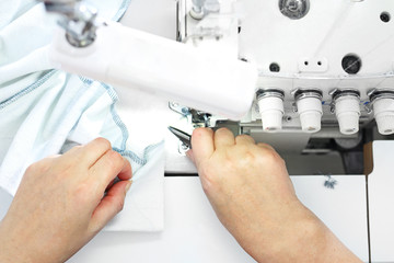 Sewing on a machine. Working woman sews on the sewing room
