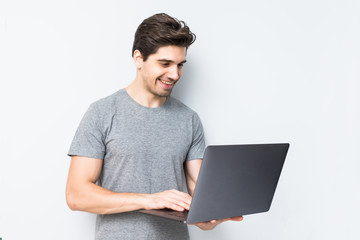 Portrait of young man with laptop isolated on white. Concept communication.