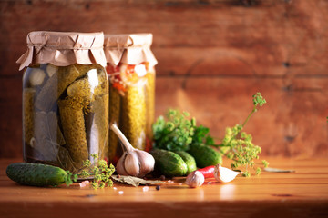Pickled cucumbers in cans over wooden background. Copy space. Canned or fermented food. Harvest preserve concept. Probiotic food