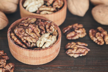 walnuts in a bowl. peeled walnuts in a wooden bowl close-up on a wooden background.