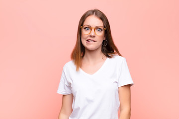 young red head woman feeling clueless, confused and uncertain about which option to pick, trying to...