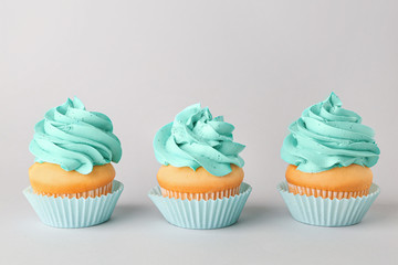 Tasty cupcakes on grey background