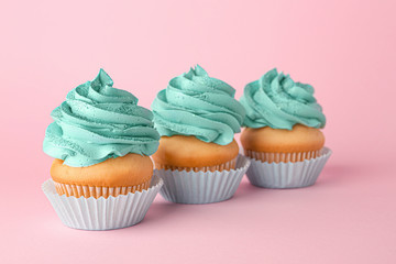 Tasty cupcakes on color background