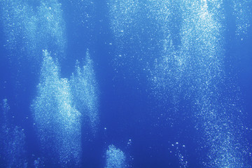 Background. The flow of air bubbles rises in the thickness of the water.