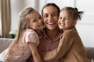 Poster Happy mother and children daughters embracing looking at camera