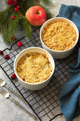 Homemade winter dessert. Apple crumbles with cranberries on a stone or slate countertop background.