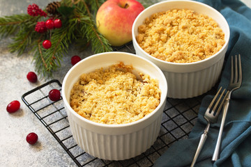 Homemade winter dessert. Apple crumbles with cranberries on a stone or slate countertop background.