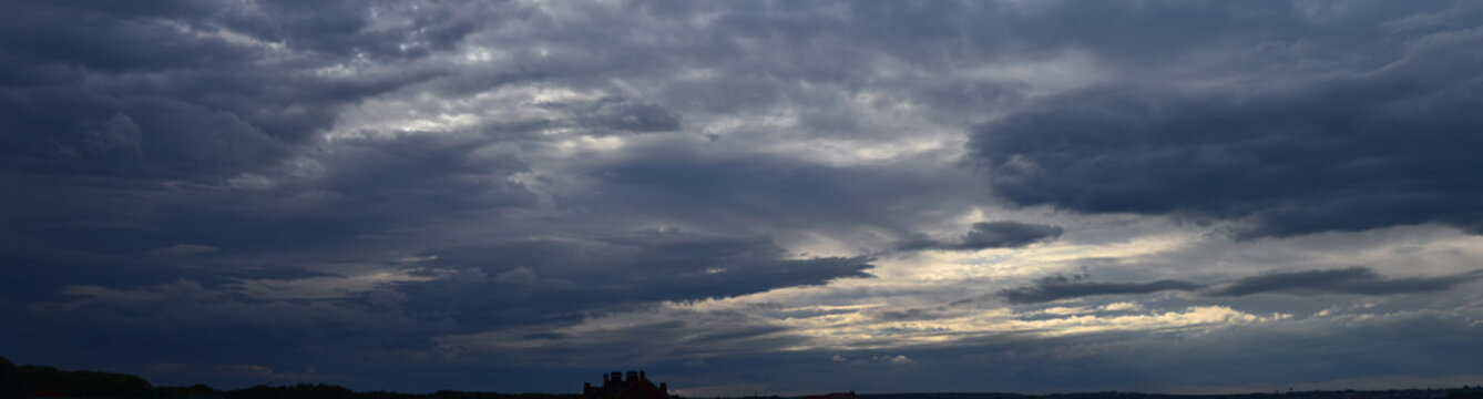 Panoramic photo of the sky. Late summer evening, dense cumulus clouds, pre-storm condition. 
