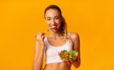 Positive Fitness Lady Enjoying Veggie Salad, Studio Shot