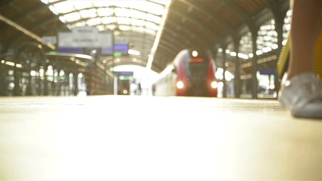 Young Caucasian Woman With Suitcase Running To Catch The Train In Before It Leaves The Station Without Her.