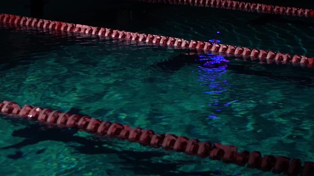 Empty pool with clear water and dividers track for swimming. Blue water in swimming pool. Night shot.
