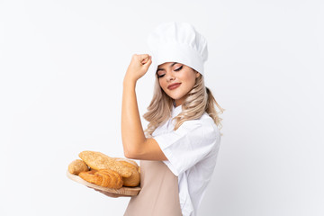 Teenager girl in chef uniform. Female baker holding a table with several breads over isolated white background making strong gesture