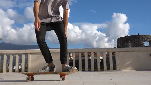Close up of skater skateboarder man doing 360 kickflip heelflip flip trick in slow motion jump