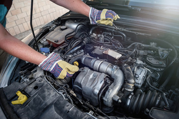 Male hands with spanners. Car service concept. Hands in protective gloves against car engine