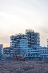 Construction of a residential quarter on the outskirts of the city on an autumn evening