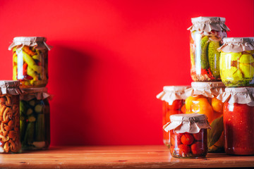 Сucumber, squash and tomatoes pickling and canning into glass jars. Ingredients for vegetables preserving. Healthy fermented food concept. Harvest storing