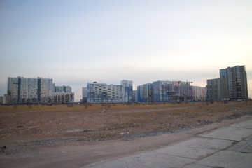Wasteland at the construction site of a residential quarter on the outskirts of the city in the autumn evening