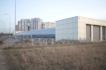 Covered pedestrian bridge on the outskirts of the city in autumn twilight