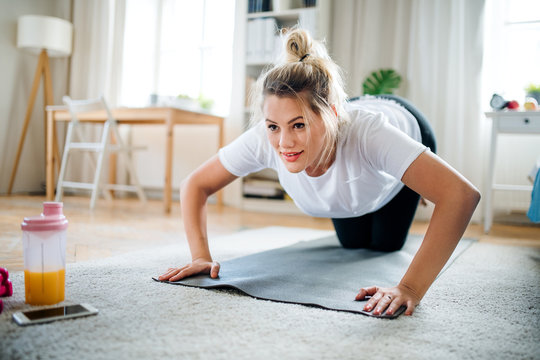 Young woman doing exercise on the floor indoors at home.