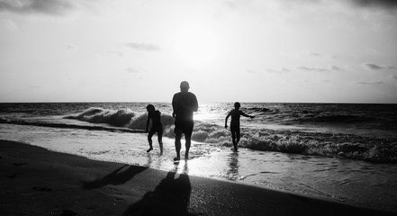 Father with two kids enjoying summer vacation on the beach