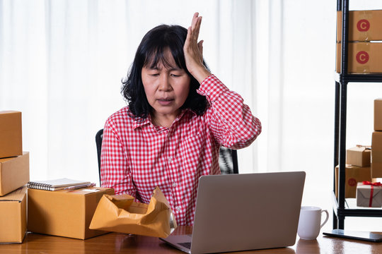 Asian women shop online  are stressed with damaged goods boxes. After customers claim products