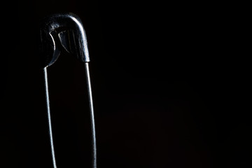 Imperdible de costura sobre fondo oscuro