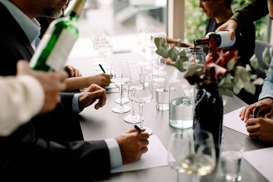 Male and business professionals with red wine at table in convention center