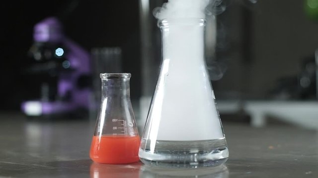 Beakers and test tubes with the solution are in the laboratory. Scientific experiment in biochemistry. chemical modern laboratory. Liquid Nitrogen evaporates from the test tube. Cryogenic freezing.