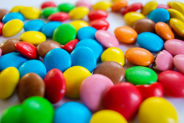Many multi-colored small round sweets are scattered on the table.