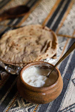 Cup of Indian yogurt with roti bread