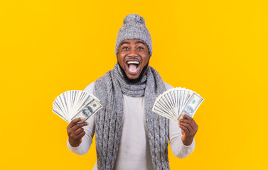 Extremely happy young black man holding money in both hands