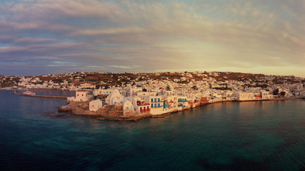 Fototapeta na wymiar Aerial drone panoramic photo of picturesque old port in main village of Mykonos island at sunset and iconic church of Paraportiani with beautiful colours, Cyclades, Greece