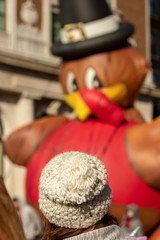 A woman wearing winter hat watching a Thanksgiving parade