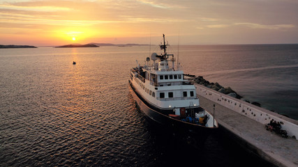 Aerial drone photo of yacht docked in old port of Mykonos island at sunset, Cyclades, Greece