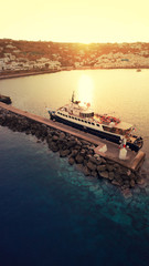 Aerial drone photo of yacht docked in old port of Mykonos island at sunset, Cyclades, Greece
