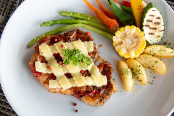  pork steak cheese on top in white plate