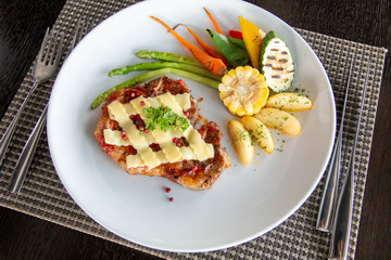  pork steak cheese on top in white plate