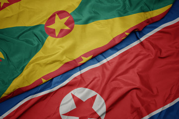 waving colorful flag of north korea and national flag of grenada.